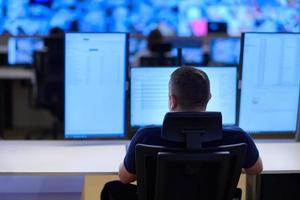 male operator working in a security data system control room photo