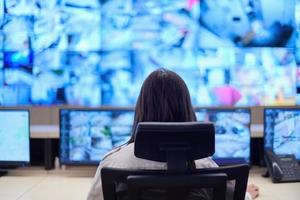 Female operator working in a security data system control room photo