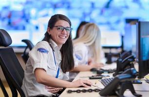 Female operator working in a security data system control room photo