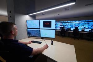 young male operator working in a security data system control room photo