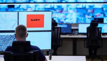 young male operator working in a security data system control room photo