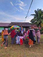 la emoción de adultos y niños que participan en una competencia de comer galletas para animar el día de la independencia de la república de indonesia, kalimantan oriental, indonesia, 13 de agosto de 2022 foto