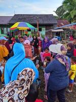 la emoción de adultos y niños que participan en una competencia de comer galletas para animar el día de la independencia de la república de indonesia, kalimantan oriental, indonesia, 13 de agosto de 2022 foto