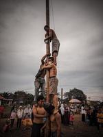 la emoción de los niños y adultos que participan en la competencia de escalada de areca para animar el día de la independencia de la república de indonesia, kalimantan oriental, indonesia, 14 de agosto de 2022 foto