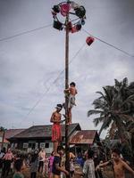 la emoción de los niños y adultos que participan en la competencia de escalada de areca para animar el día de la independencia de la república de indonesia, kalimantan oriental, indonesia, 14 de agosto de 2022 foto