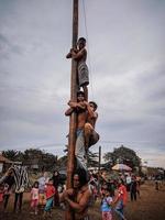 the excitement of children and adults taking part in the areca climbing competition to enliven the independence day of the republic of Indonesia, east kalimantan, indonesia, august, 14,2022 photo