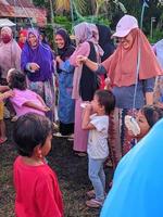 the excitement of adults and children taking part in a cracker eating competition to enliven the independence day of the republic of Indonesia, East Kalimantan, Indonesia August 13, 2022 photo