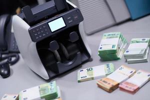 Billetes frente a la máquina contadora de dinero electrónico foto