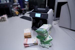 Billetes frente a la máquina contadora de dinero electrónico foto