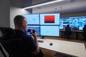 young male operator working in a security data system control room photo