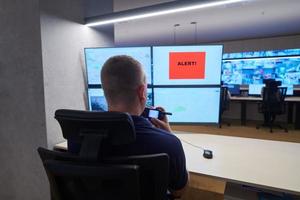 young male operator working in a security data system control room photo