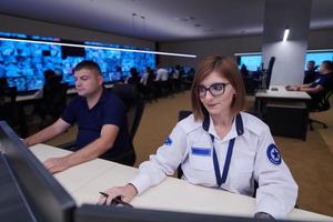 Female operator working in a security data system control room photo
