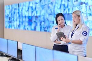 Female security guards working in a security data system control room photo
