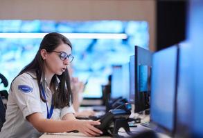 Female operator working in a security data system control room photo