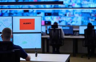 young male operator working in a security data system control room photo