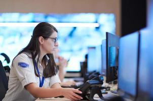 Female operator working in a security data system control room photo