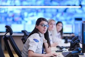 Female operator working in a security data system control room photo