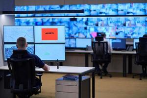 young male operator working in a security data system control room photo