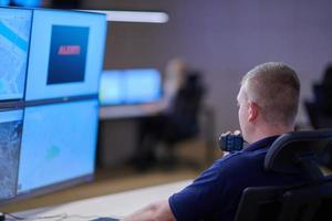 young male operator working in a security data system control room photo