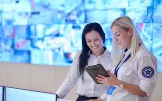 Female security guards working in a security data system control room photo
