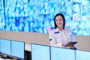 Female operator working in a security data system control room photo