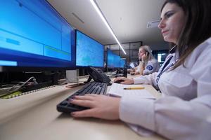 Female security guards working in a security data system control room photo