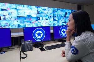 Female operator working in a security data system control room photo