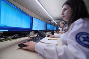 Female security guards working in a security data system control room photo