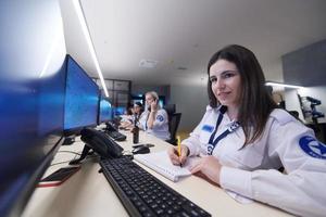 Female security guards working in a security data system control room photo