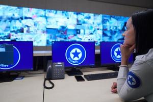 Female operator working in a security data system control room photo