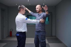 guardia de seguridad haciendo procedimiento de registro corporal en el hombre foto