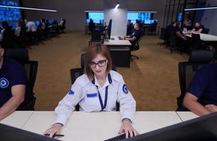 Female operator working in a security data system control room photo