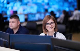 Female operator working in a security data system control room photo