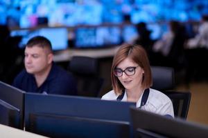 Female operator working in a security data system control room photo