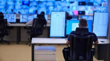 male operator working in a security data system control room photo