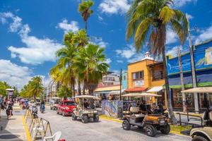 ISLA MUJERES, MEXICO - APR 2022 golf cars on the street among palms near Cancun photo