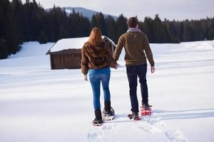 pareja divirtiéndose y caminando con raquetas de nieve foto