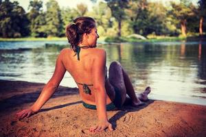 girl in a green bikini relaxing on the riverbank photo