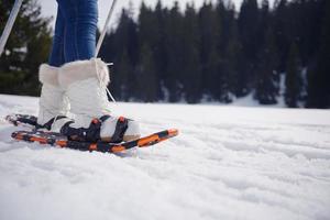 couple having fun and walking in snow shoes photo