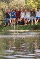 friends enjoying watermelon while sitting on the wooden bridge photo