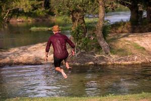 man jumping into the river photo