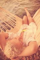 blonde woman resting on hammock photo