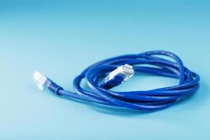 Blue Ethernet Cable Cord Patch cord on a blue background with free space photo