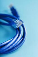 Cable de conexión de cable ethernet azul sobre un fondo azul con espacio libre foto