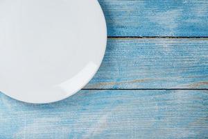 White plate on a blue background top view. photo