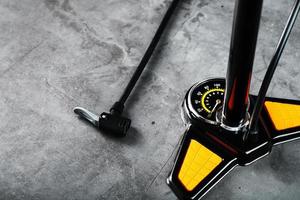 Air pump with a manometer and a wheel inflation hose on a dark background with free space photo