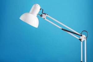 White table office lamp on blue background with space for text and idea concept photo