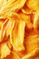 Dried sweet mango fruit slices as textural orange photo