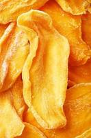 Pieces of sweet dried mango close-up as a background in full screen photo