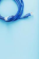 A coil of an Internet network cable for data transmission on a blue background photo